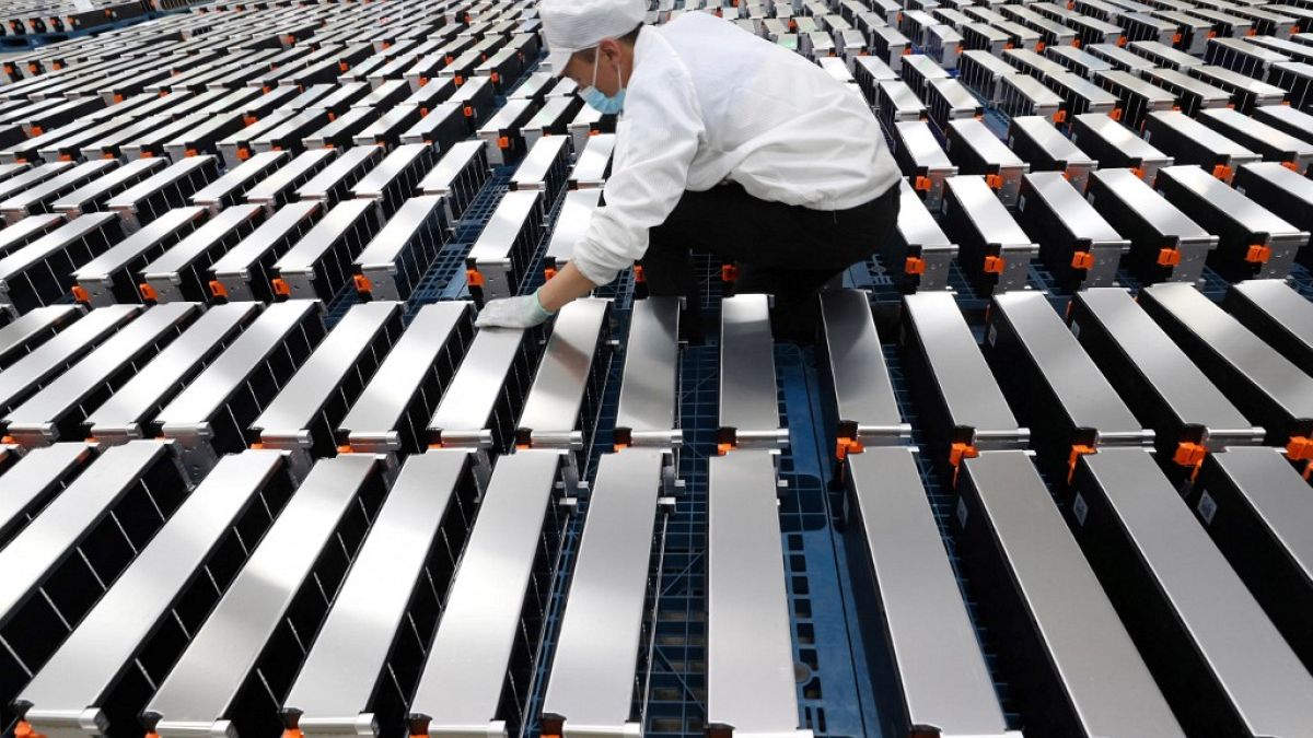 This photo taken on March 12, 2021 shows a worker with car batteries at a factory for Xinwangda Electric Vehicle Battery Co, which makes lithium batteries for electric cars. 