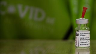 A pharmacist prepares to fill a syringe from a vial of the AstraZeneca COVID-19 vaccine at the Vaccine Village in Antwerp, Belgium on Tuesday, March 16, 2021.