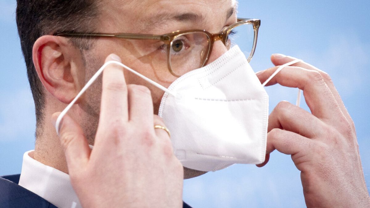 Der deutsche Gesundheitsminister Jens Spahn setzt sich nach einer Pressekonferenz seine FFP-2 -Maske auf