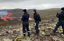 Agentes da Guarda Costeira Islandesa observam a erupção em Reykjanes
