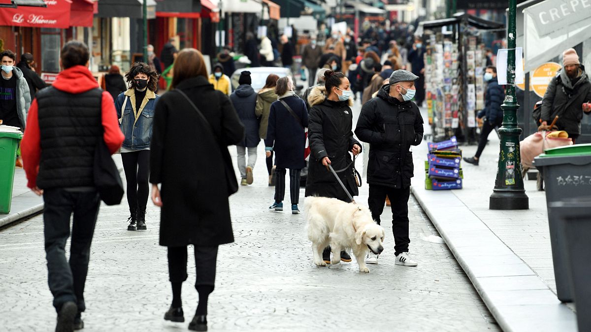 People walk on a pedestrian street in Paris with non-essential shops shut on the first day of a one-month lockdown  in the Ile-de-France region on March 20, 2021.  