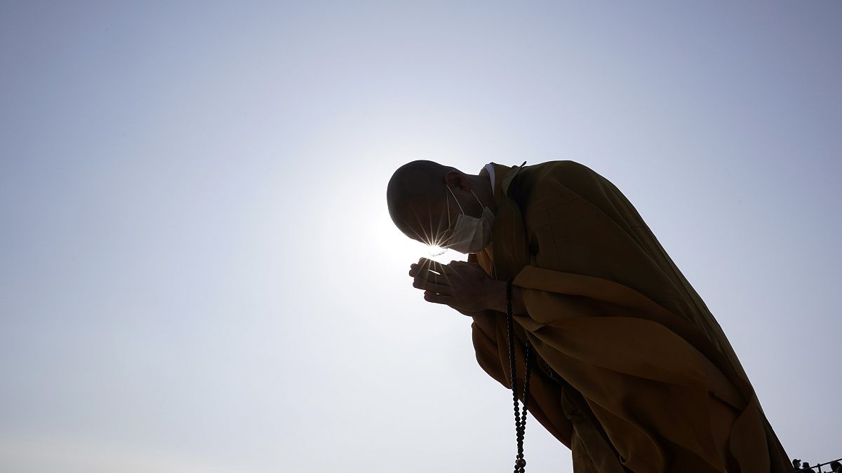 Az áldozatokért imádkozik egy buddhista szerzetes Szendai óceánpartján a szökőár 10. évfordulóján