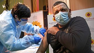An Albanian nurse administers a AstraZeneca coronavirus vaccine to a Kosovo doctor in the northern Albanian town of Kukes on Saturday, March 20, 2021.