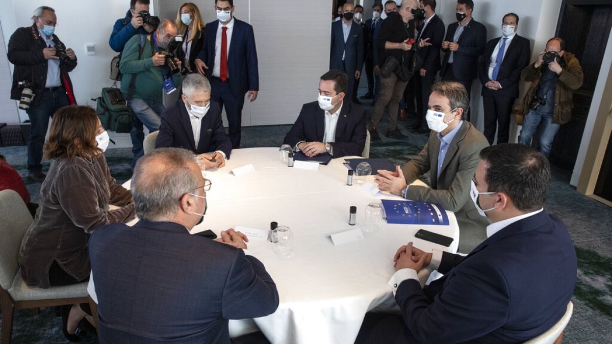 Greece's Prime Minister Kyriakos Mitsotakis, right, attends a ministerial meeting in Athens, Saturday, March 20, 2021.