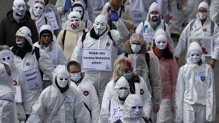 متظاهرون يرتدون ملابس بيضاء خلال مظاهرة ضد قيود فيروس كورونا المستمرة في بازل، في 20 مارس 2021.