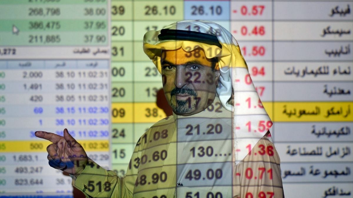 یک کارگزار بورس عربستان در حال توضیح در مورد روند قیمت سهام شرکت‌ها از جمله آرامکو