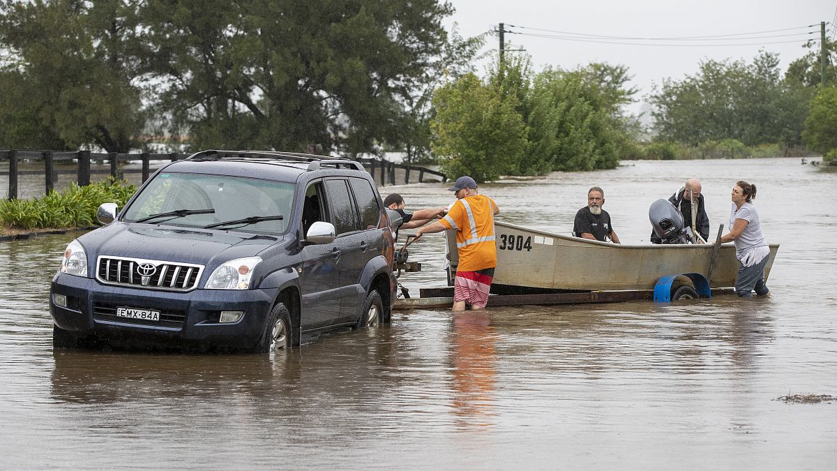 A boat is loaded back onto its trailer on a flooded road at Old Pitt Town, north west of Sydney, Australia, Sunday, March 21, 2021.