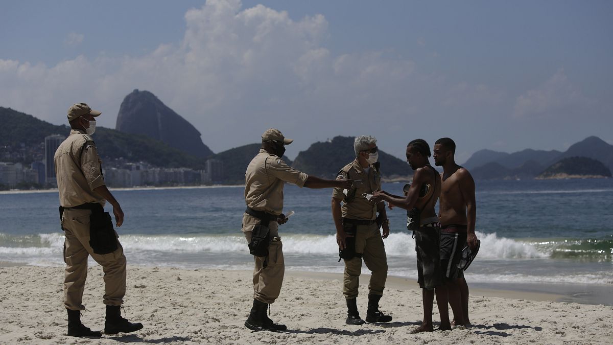 Police work to keep beachgoers off the Arpoador beach which is closed due to reinstated COVID-19 pandemic restrictions in Rio de Janeiro, Brazil, Saturday, March 20, 2021.