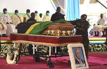 أفراد من قوات الدفاع الشعبية التنزانية يضعون العلم الوطني على نعش الرئيس التنزاني الخامس جون ماجوفولي خلال الجنازة الوطنية في ملعب أوهورو في دار السلام.