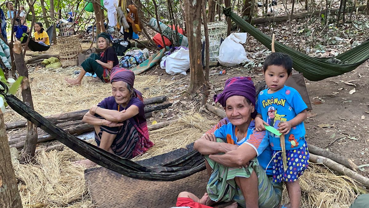 In this photo released by the Free Burma Rangers, Karen women sit with family members in the jungles of northern Karen State, Myanmar.  