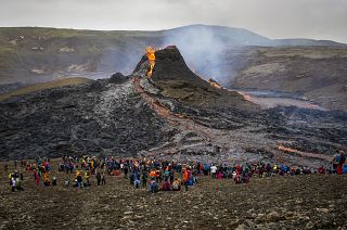  Hikers look at the lava flowing from the erupting Fagradalsfjall volcano, 40 km west of the Icelandic capital Reykjavik. March 21, 2021