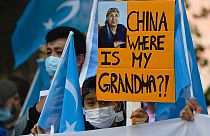 شاب من أقلية الإيغور يحمل لافتة كتب عليها "الصين أين جدتي ؟ خلال مظاهرة يوم 1 سبتمبر 2020 أمام مبنى  وزارة الخارجية في برلين