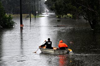 Residents commute via boat in a flooded residential area near Windsor, New South Wales. 
