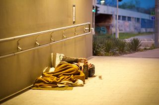A man lies on the street smoking a cigarette in Budapest, Hungary
