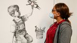 A member of staff at University Hospital Southampton poses with Banksy's "Game Changer" artwork. May 7, 2020