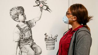 A member of staff at University Hospital Southampton poses with Banksy's "Game Changer" artwork. May 7, 2020