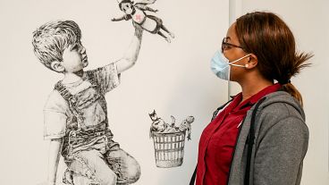 A member of staff at University Hospital Southampton poses with Banksy's "Game Changer" artwork. May 7, 2020