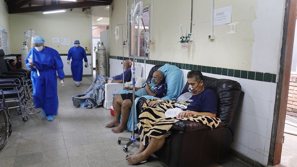 Varios enfermos de COVID-19 sin camas son tratados en los pasillos de un hospital en San Lorenzo, Paraguay.