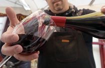 A wine storekeeper pours red wine in a glass during a presentation in a wine shop in Paris, Thursday Nov. 20, 2014