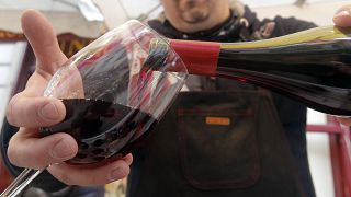 A wine storekeeper pours red wine in a glass during a presentation in a wine shop in Paris, Thursday Nov. 20, 2014