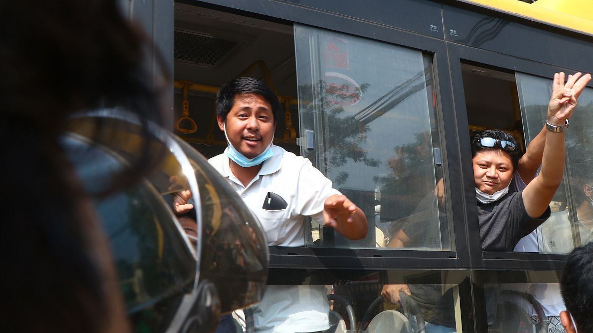 An arrested protester flashes the three-fingered salute while onboard a bus getting out of Insein prison to go to an undisclosed location on March 24, 2021 in Yangon, Myanmar 