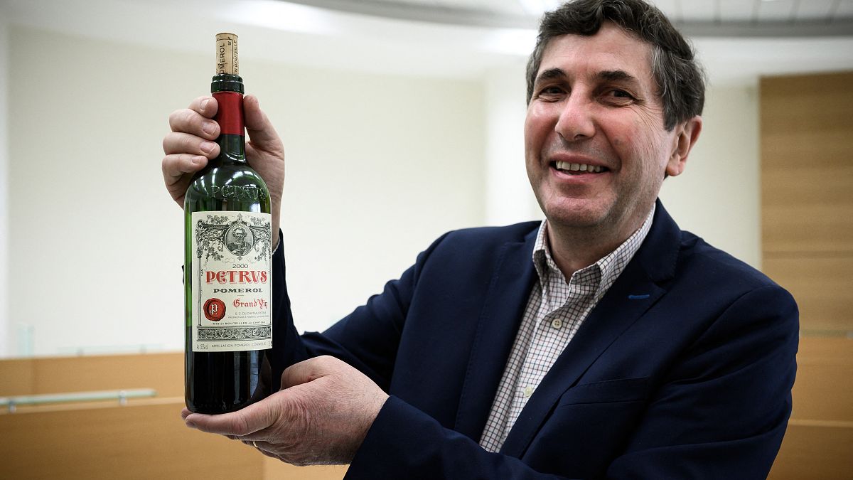 Philippe Darriet, Direktor der Önologie-Forschungseinheit am Institut für Reben, Wissenschaft und Wein (ISVV) hält eine Flasche Petrus, die Monate im Weltraum verbracht hat