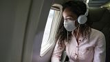 A passenger looks out of a window on a plane