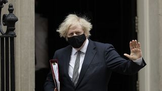 British Prime Minister Boris Johnson waves at the media as he leaves 10 Downing Street for the Houses of Parliament, in London, Wednesday, March 24, 2021. 