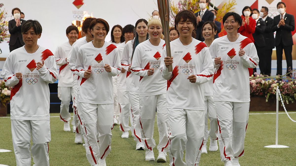 Die japanische Frauen-Fußballnationalmannschaft mit der Fackel