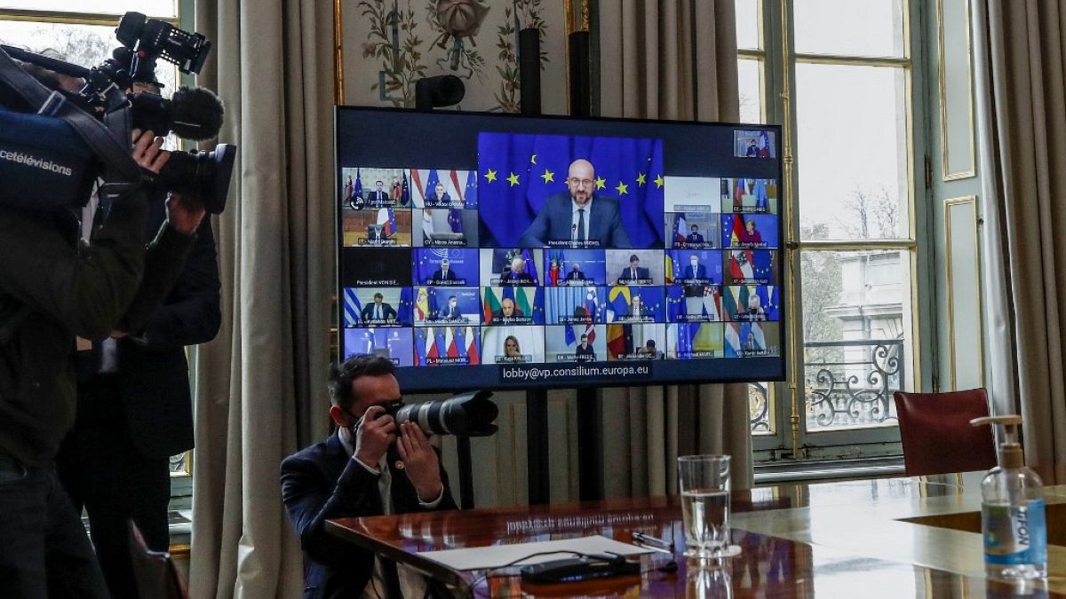 Journalists work as European Council President Charles Michel is seen on a screen during a European Union summit