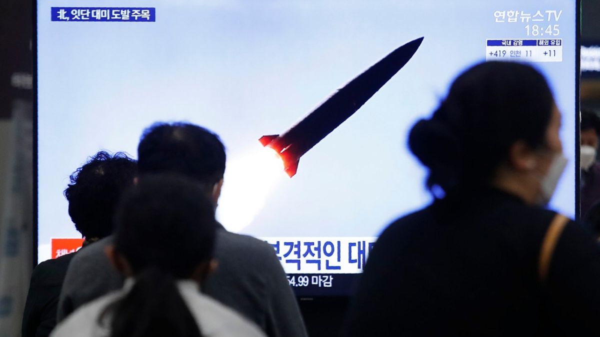 كوريون جنوبيون في محطة قطارات سوسيو في سيول يتابعون إطلاق صاروخ كوري شمالي خلال برنامج إخباري، 25 مارس 2021
