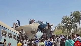A video grab taken from Egyptian state television shows people gathered around two trains that collided in the Tahta district on March 26, 2021.