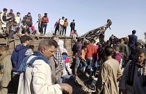 Egyptians look for remains of victims around mangled train carriages at the scene of a train accident in Sohag, Egypt, Friday, March 26, 2021.(AP Photo)