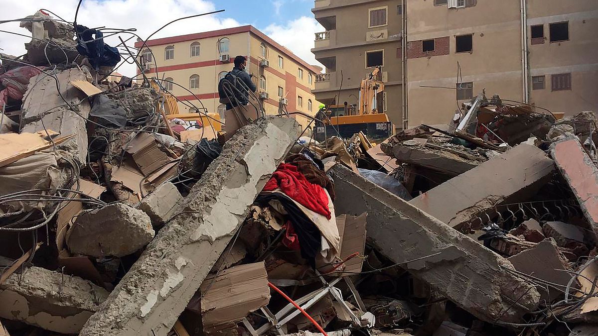 Emergency workers sift through the rubble of a collapsed apartment building in the el-Salam neighborhood
