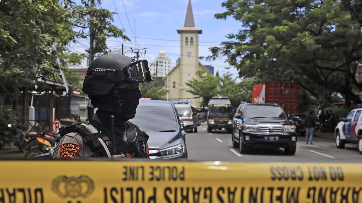 A police officer stands guard near a church where an explosion went off in Makassar, South Sulawesi, Indonesia, Sunday, March 28, 2021. 