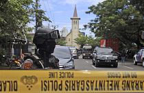 A police officer stands guard near a church where an explosion went off in Makassar, South Sulawesi, Indonesia, Sunday, March 28, 2021.