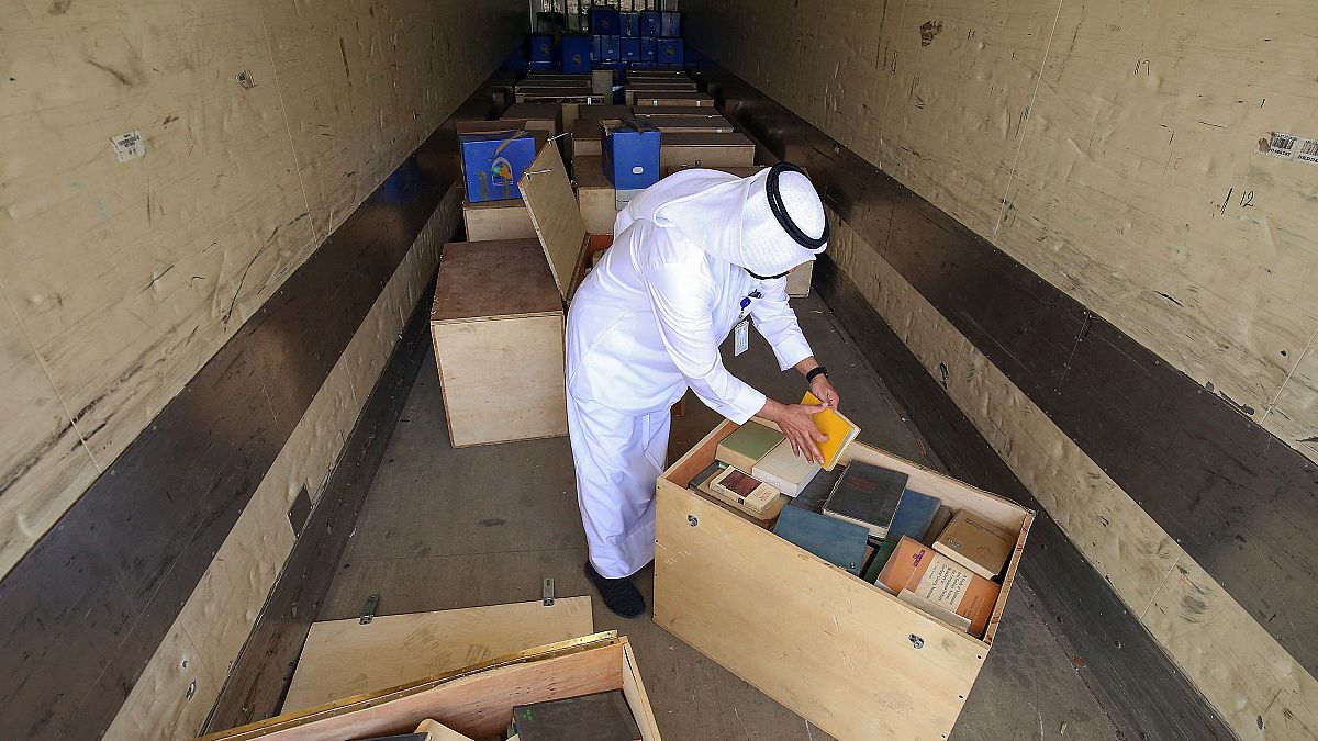 موظف في وزارة الإعلام الكويتية يتفقد صناديق أرشيفات كويتية بعد استردادها من العراق، 28 مارس 2021
