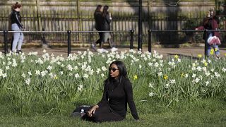 A woman enjoys spring weather in Green Park as lockdown continues in London, Tuesday, March 23, 2021