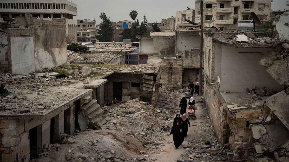 نساء يسرن في حي تضرر بشدة من الغارات الجوية في إدلب ، سوريا/ 12 مارس / آذار 2020 