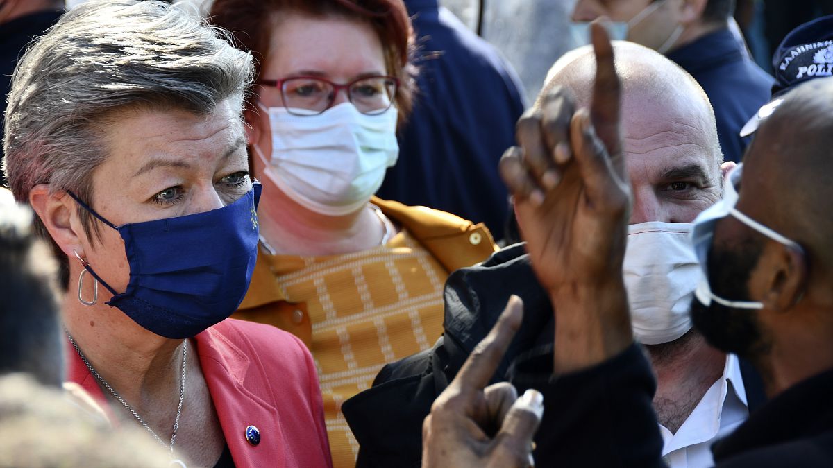 EU Commissioner Ylva Johansson, left, listens to an asylum seeker at a refugee camp in the port of Vathy on the eastern Aegean island of Samos, Greece, March 29, 2021.