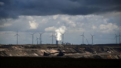 Wind turbines are seen near the open-cast mining and the coal-fired power station Neurath of German energy giant RWE in Garzweiler, western Germany. Wind turbines are seen near the open-cast mining and the coal-fired power station Neurath of German energy giant RWE in Garzweiler, western Germany.