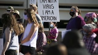 أمريكية من أصول آسيوية تحمل لافتة تقول أنا لست فيروسا بل أمريكية، خلال احتجاج ضد الكراهية الآسيوية في تولسا، أوكلا.