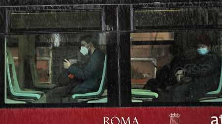 People wearing face masks to curb the spread of COVID-19, sit at distance in a tram in downtown Rome, Monday, March 15, 2021.