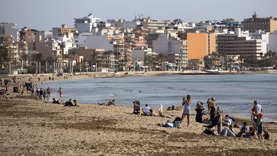 Tourists enjoy the beach at the Spanish Balearic Island of Mallorca, Spain, Monday, March 29, 2021.