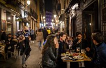 Tourists and locals have drinks at a bar in downtown Madrid, Spain, Friday, March 26, 2021.