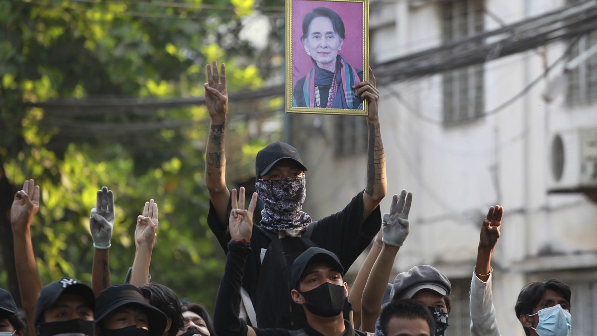 Anti-coup demonstrators raise the three finger of resistance and a portrait of deposed leader Aung San Suu Kyi. Yangon, Myanmar. April 1, 2021.