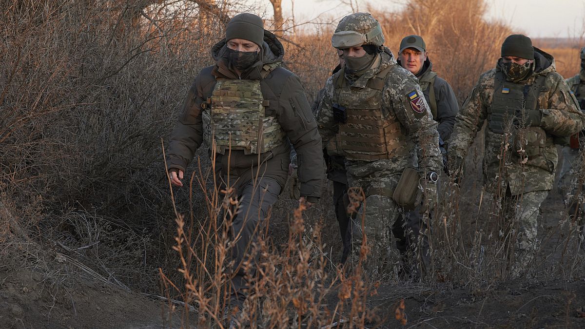 Ukrainian President Volodymyr Zelenskiy, left, inspects Ukrainian armed forces' positions as he visits Donetsk region, Ukraine, Sunday, Dec. 6, 2020