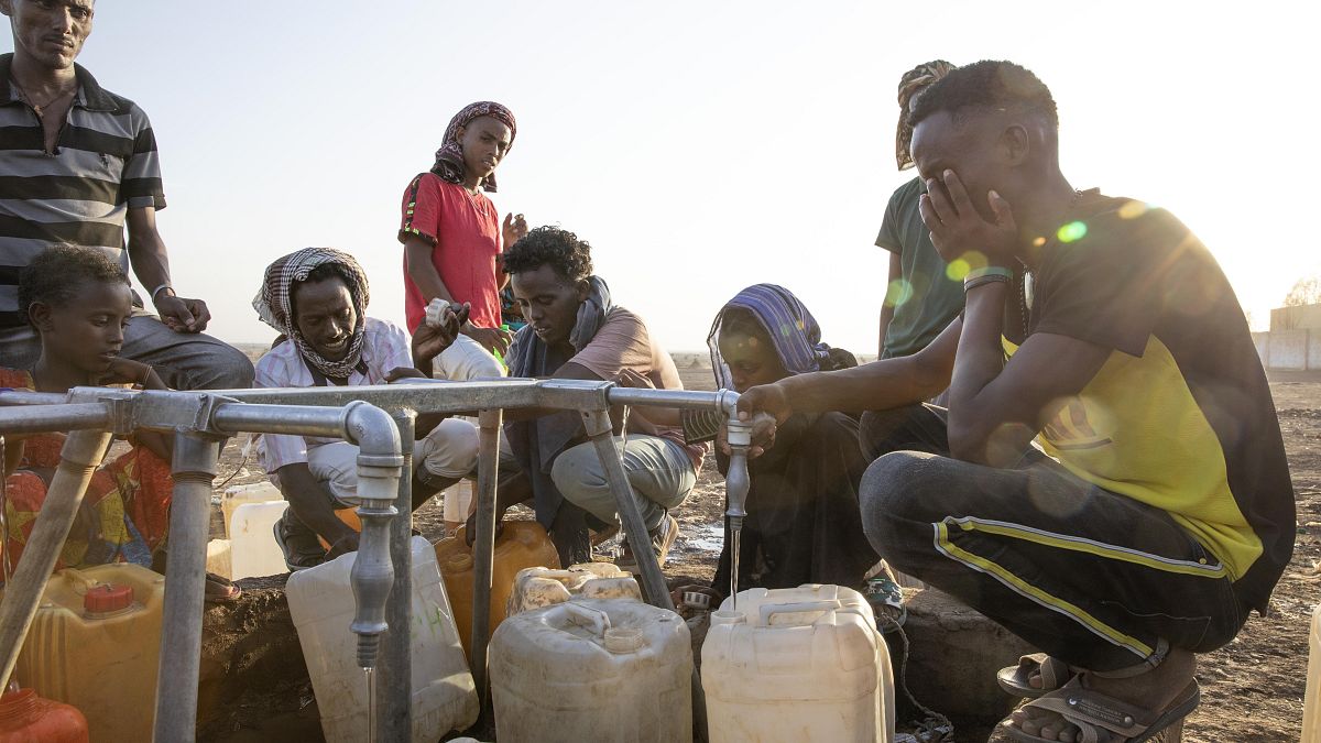 Tigrayan refugees fill their gallons with water at a water station at Hamdeyat Transition Center near the Sudan-Ethiopia border, eastern Sudan, March 24, 2021.
