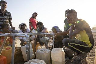 Tigrayan refugees fill their gallons with water at a water station at Hamdeyat Transition Center near the Sudan-Ethiopia border, eastern Sudan, March 24, 2021.