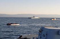 Yunan Sahil Güvenliği tarafından paylaşılan fotoğrafta, Midilli ile Türkiye kıyıları arasında, arka planda Türk gemileri ile solda göçmenlerin bulunduğu bir sandal görülüyor